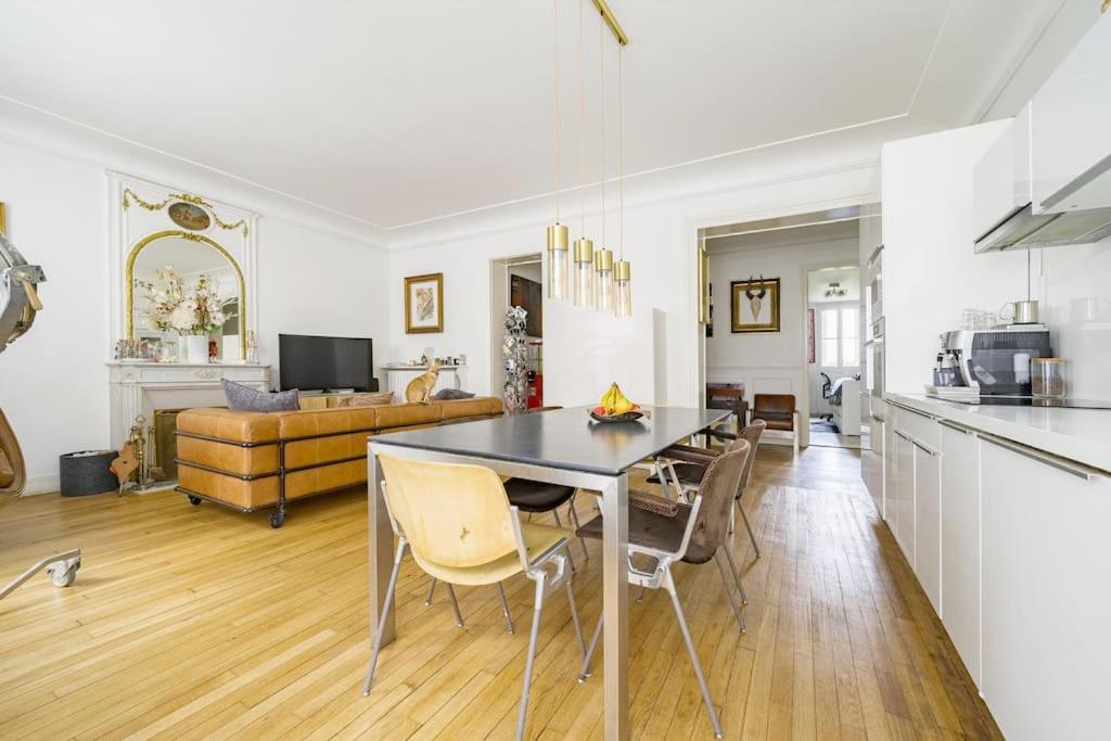 eine Küche und ein Wohnzimmer mit einem Tisch und Stühlen in der Unterkunft Magnifique appartement Lumineux in Saint-Mandé