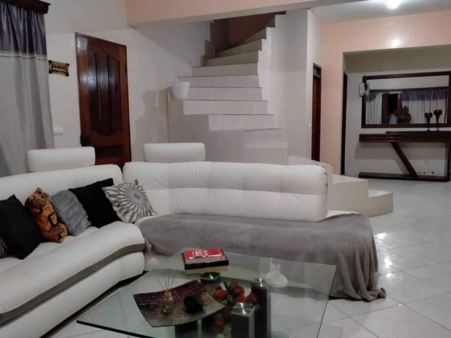 a living room with a white couch and a glass table at Kaza Mamai di Fora, o conforto da sua estadia in Calheta de São Miguel