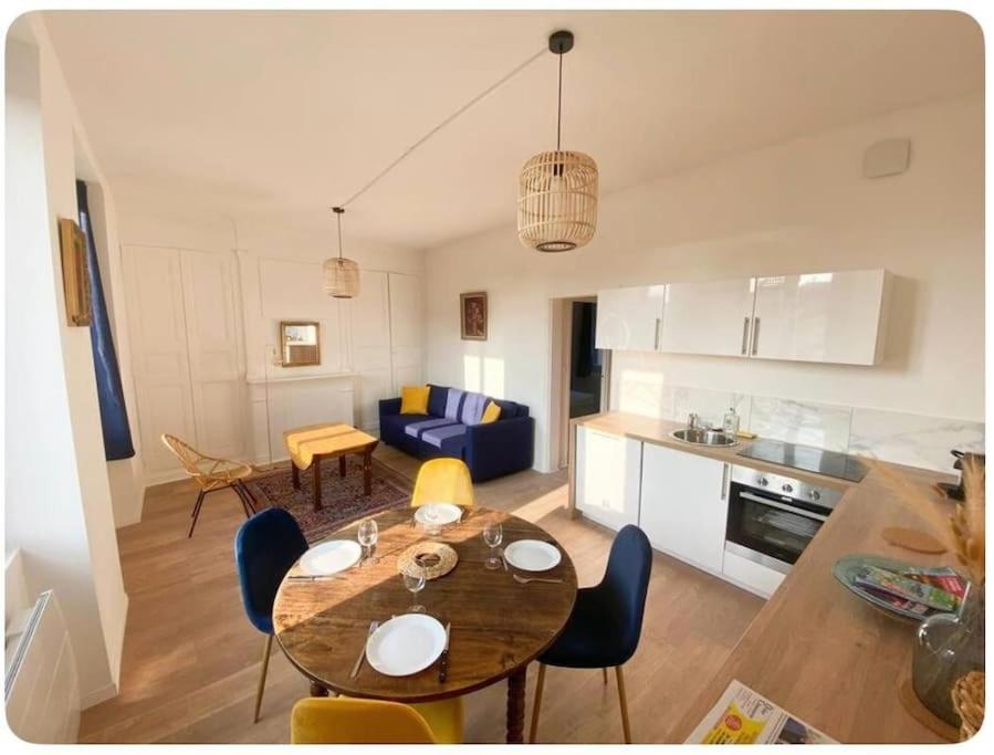 een keuken en een woonkamer met een tafel en stoelen bij L'écrin in Angers
