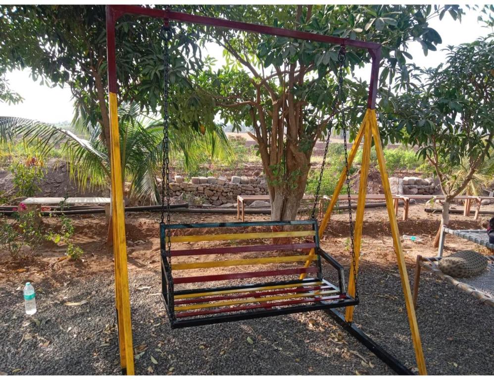 a swing in a park with two yellow poles at Samrat Farm House, Jalandhar in Chāndawāri