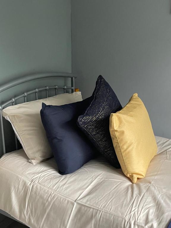 a pile of pillows sitting on top of a bed at Stunning Spacious One Bedroom Haven in Wyken