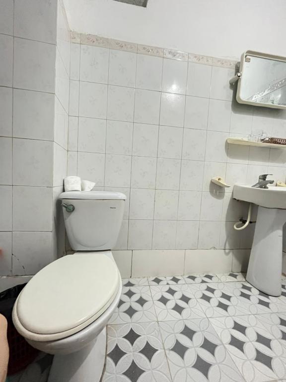 a white bathroom with a toilet and a sink at Thanh Lam Hotel in Sầm Sơn