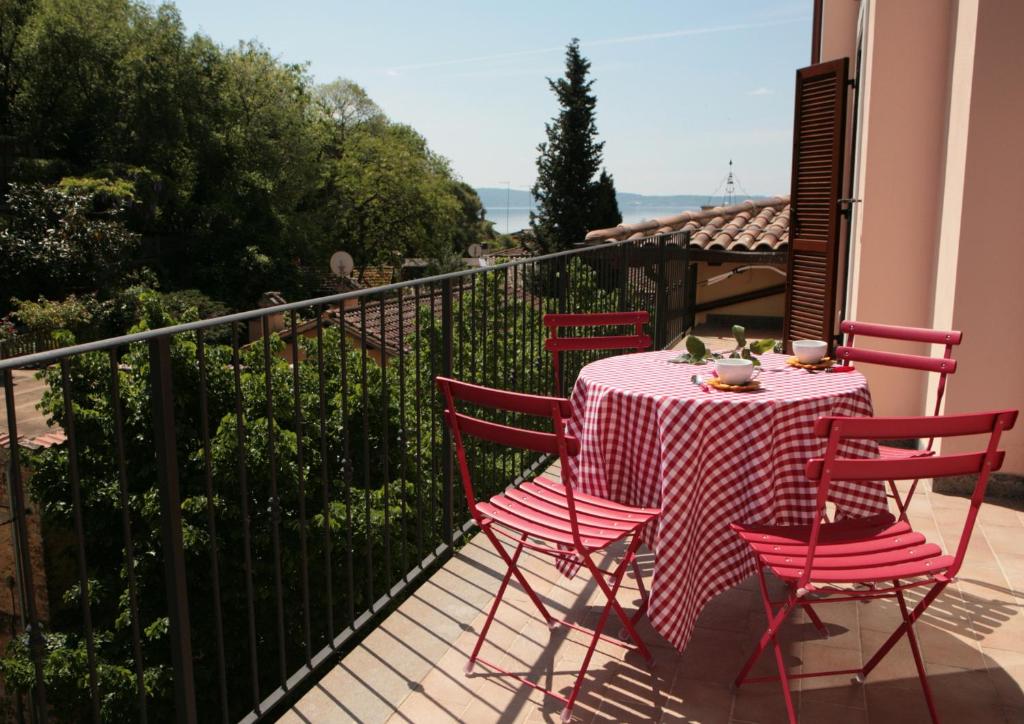 uma mesa com cadeiras vermelhas sentadas numa varanda em Casa Vacanze Relax in Piazzetta em Trevignano Romano