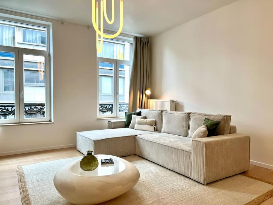 a living room with a couch and a coffee table at Duplex chic et spacieux - Hypercentre in Liège