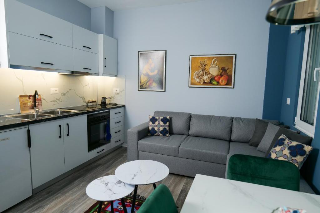 a living room with a couch and a table at Travelers' Korça Home in Korçë