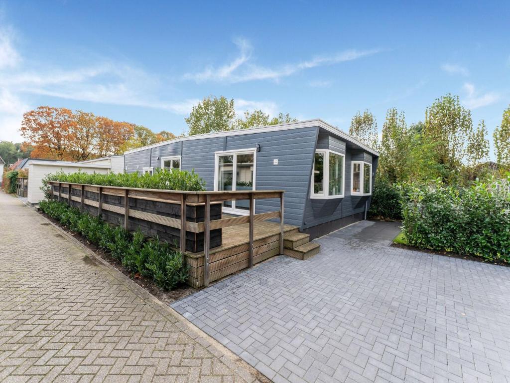 een klein grijs huis met een houten terras bij Charming Holiday Home in Kaatsheuvel near Efteling in Kaatsheuvel