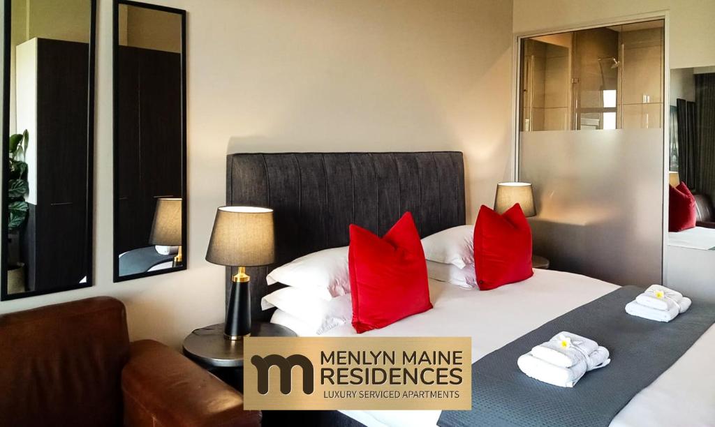 プレトリアにあるMenlyn Maine Residences - Paris king sized bedの赤い枕のベッドが備わるホテルルームです。