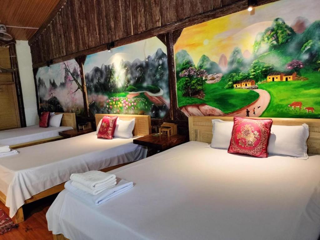 a room with three beds with a painting on the wall at Mai's Homestay Dong Van in Dồng Văn