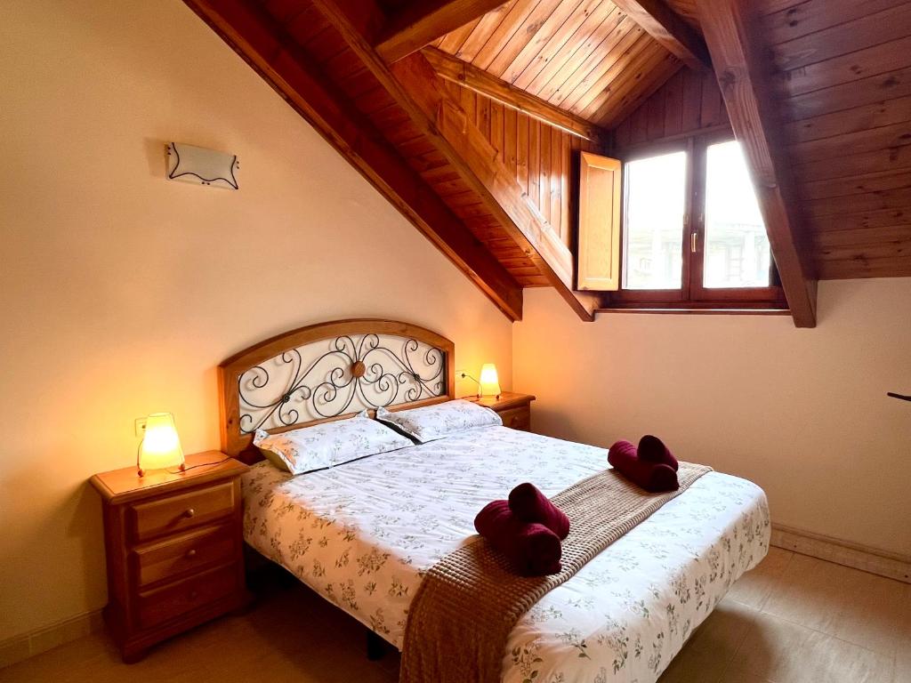 a bedroom with a bed with two red bows on it at Dúplex el Torrent in Sort