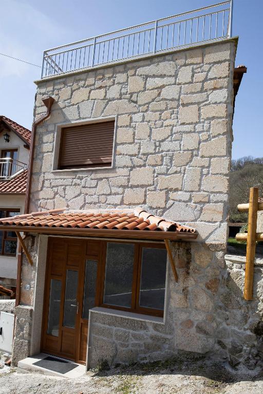 a stone building with a window and a roof at Casa Larán in Chantada