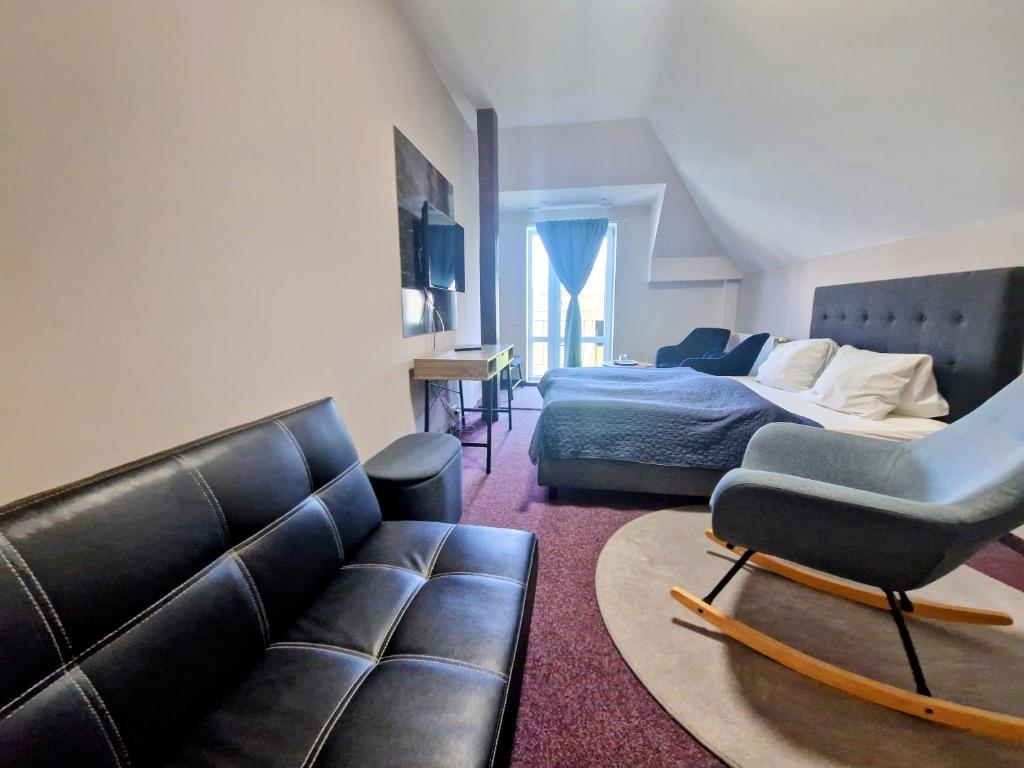 a living room with a couch and a bed at Family hotel Maxim in Beroun
