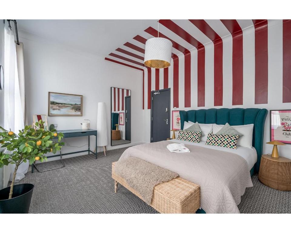 a bedroom with a bed and a striped wall at The Wellesley in Belfast