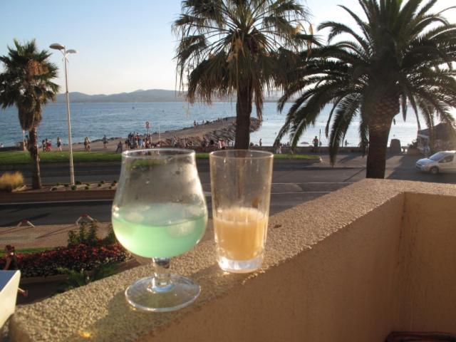 un verre d'eau et un verre assis sur un grand livre dans l'établissement Appartement les pieds dans l'eau pour 6 personnes à Saint-Raphaël, à Saint-Raphaël