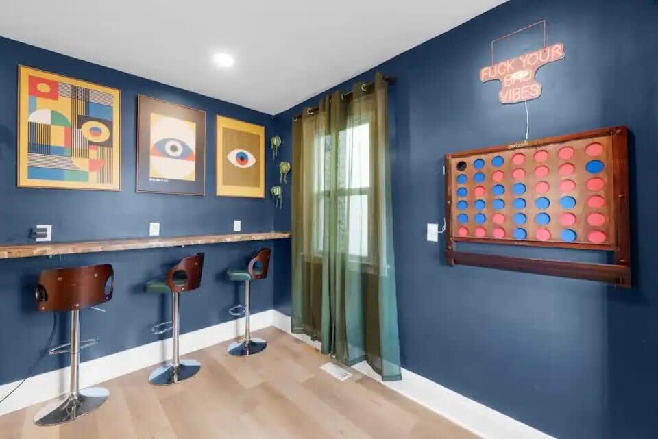 Cette chambre est dotée d'un mur bleu avec tabourets de bar. dans l'établissement 5 Bedrooms Sleeps 14 Hot Tub Fire Pit, à Columbus