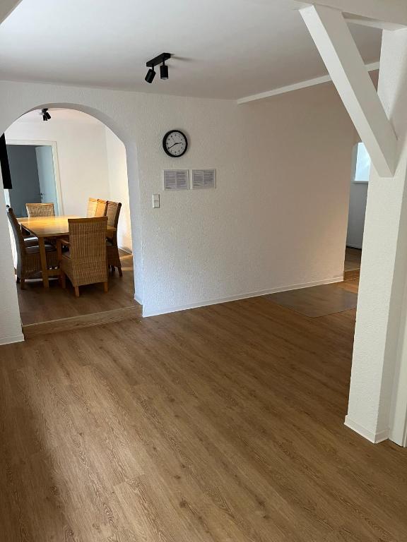 a dining room with a table and a clock on a wall at Apartments zum Wildgehege in Siegen