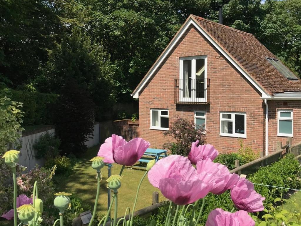 a house with pink flowers in front of it at 2 Bed in Lulworth 94448 in Winfrith Newburgh