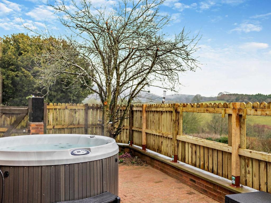 a hot tub sitting next to a wooden fence at 3 Bed in Bridgnorth 94532 