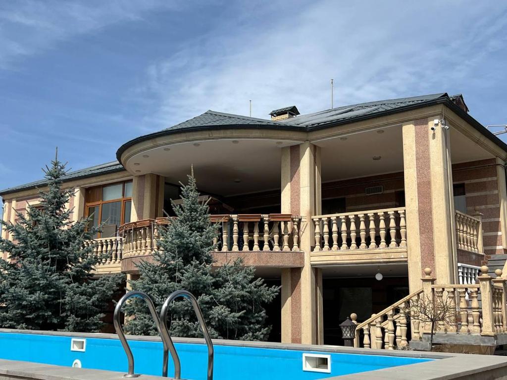 une grande maison avec une piscine en face de celle-ci dans l'établissement Villa Nor Hachn, Kotayq, à Nor Hachyn