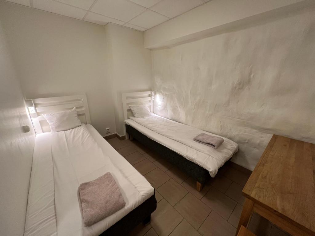 a room with two beds and a table in it at Hostel Dalagatan in Stockholm