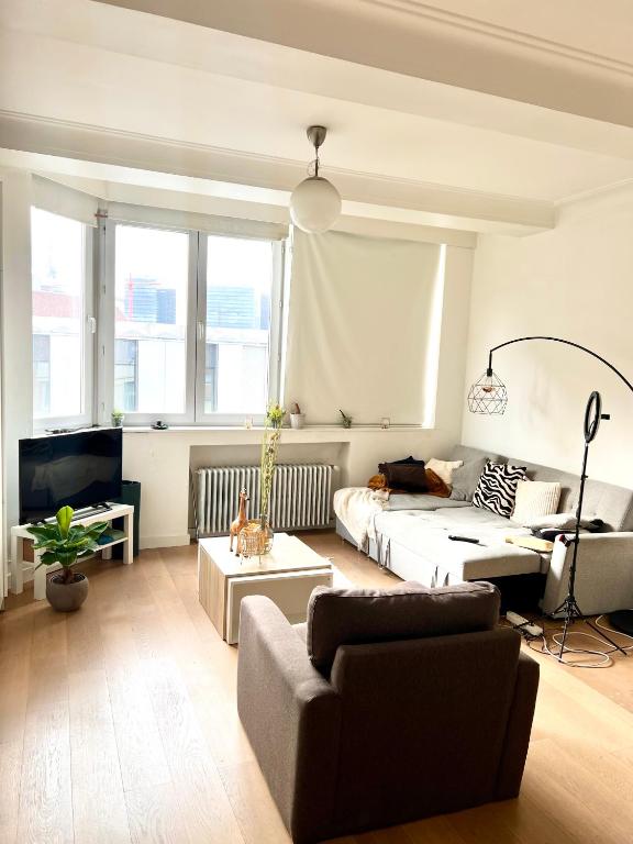 ein Wohnzimmer mit einem Sofa und einem Bett in der Unterkunft Lumineux Haussmanien du Nord in Brüssel