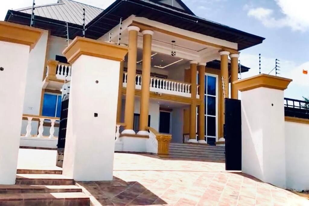 a house with columns and a roof at Nanani Villa - Harmonious Paradise in Kumasi