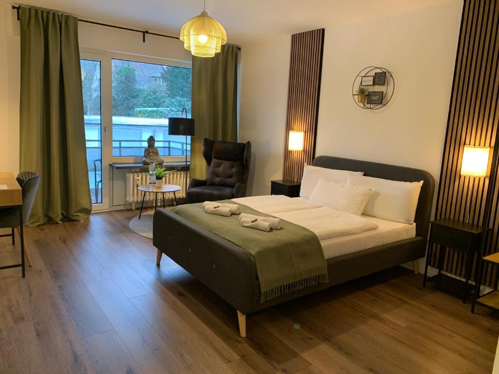 a bedroom with a bed and a chair and a window at Businessapartment I Balkon I Messe I Parken I schnelles WLAN in Essen