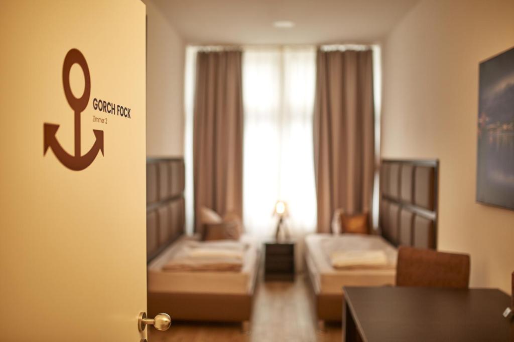 een kamer met 2 bedden en een woonkamer met een tafel bij Harbour Apartments in Karlsruhe