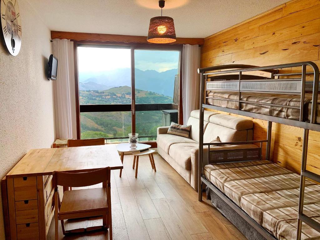 a room with bunk beds and a table and a desk at Appartement avec balcon au pied des pistes de ski in Villarembert