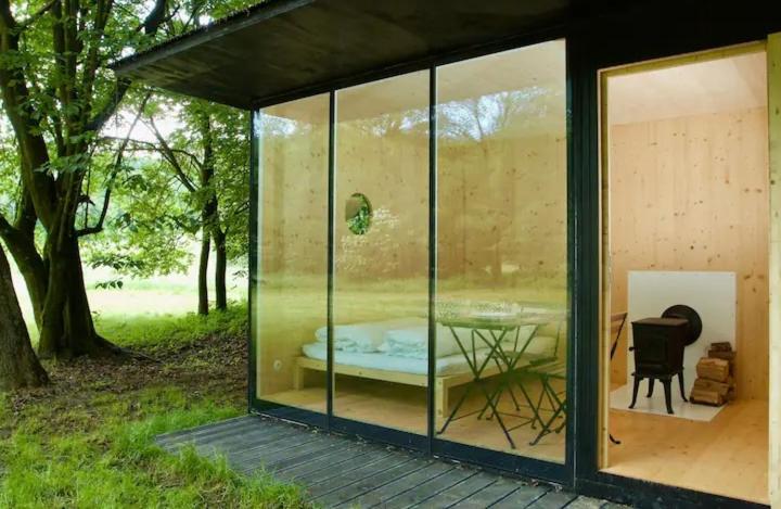 a glass house with a table inside of it at Tiny house u Dlouhé řeky in Buchlovice