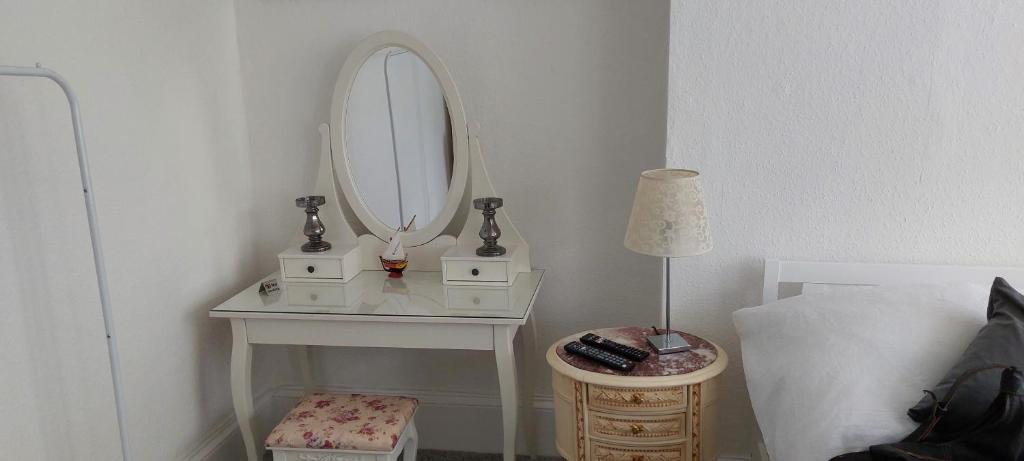 a white dressing table with a mirror and a lamp at Sail Loft in Brighton & Hove