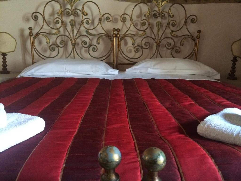 a bed that has a red blanket on top of it at La Piazzetta Toscana B&B in Campiglia Marittima