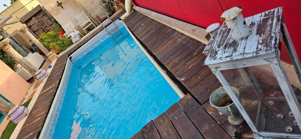 una piscina azul en una terraza de madera en Quiet place 3 km from the beach of Cesarea en Or ‘Aqiva