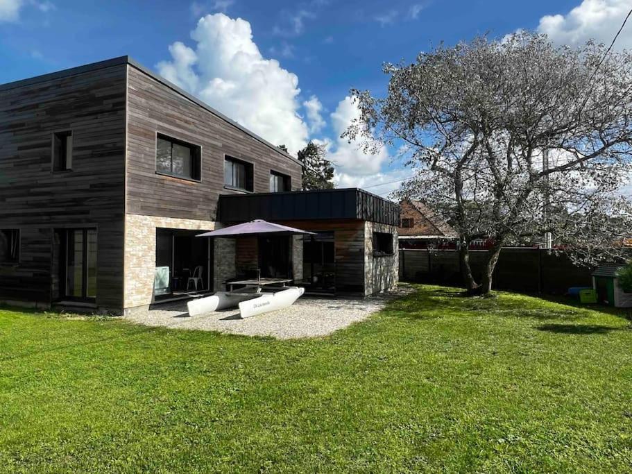 une maison avec deux bancs blancs dans une cour dans l'établissement La Villa Case-Bi, à Saint-Germain-sur-Ay