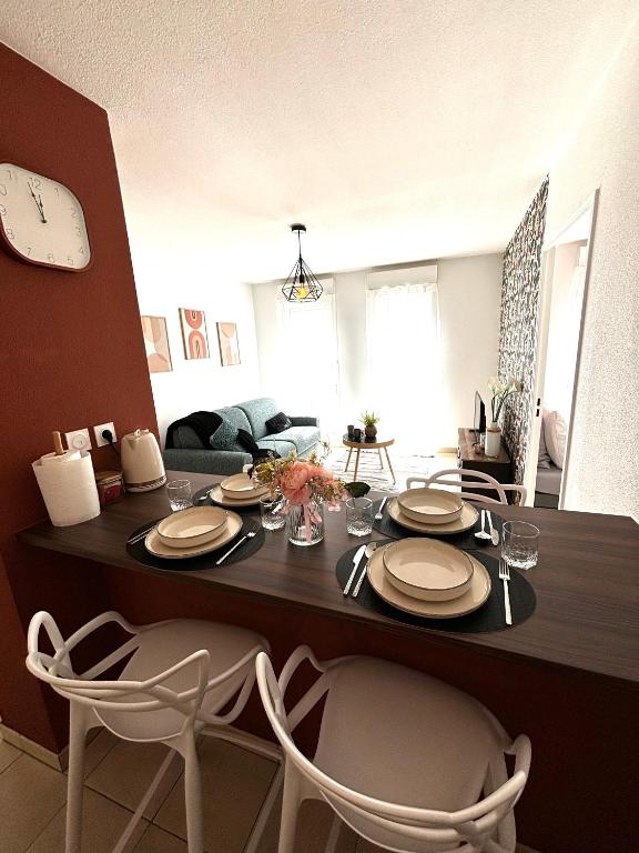 une table à manger avec des chaises et une horloge murale dans l'établissement l'Havana : Proche Gare Partdieu / aéroport / groupama stadium, à Villeurbanne