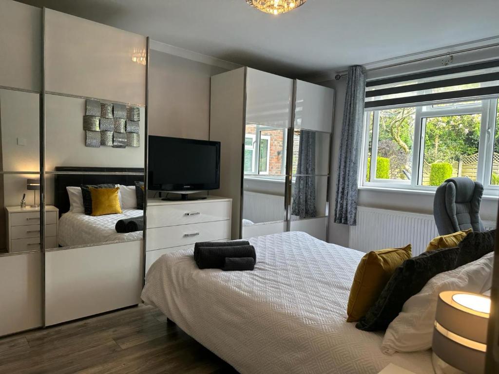 um quarto com duas camas e uma televisão em A luxury double bedroom with ensuite in High Wycombe em Buckinghamshire