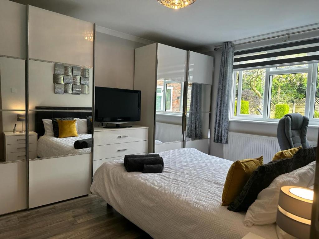 a bedroom with two beds and a television in it at A luxury double bedroom with ensuite in High Wycombe in Buckinghamshire