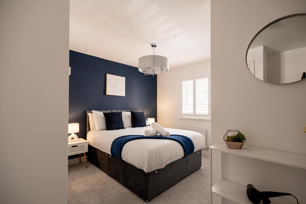 - une chambre dotée d'un lit avec un mur bleu dans l'établissement Gibson House By Horizon Stays, à Stockton-on-Tees