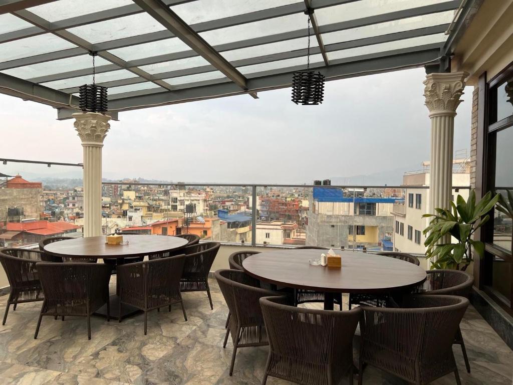 Dees Boutique Hotel في كاتماندو: طاولتين على شرفة مطلة على مدينة
