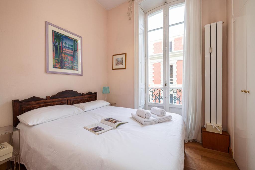 a bedroom with a white bed with towels on it at Regina - Happy Rentals in Menton