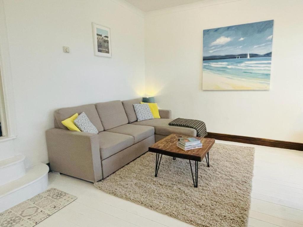 a living room with a couch and a coffee table at Lovely Seaside Ground Floor Cottage Old Leigh in Leigh-on-Sea