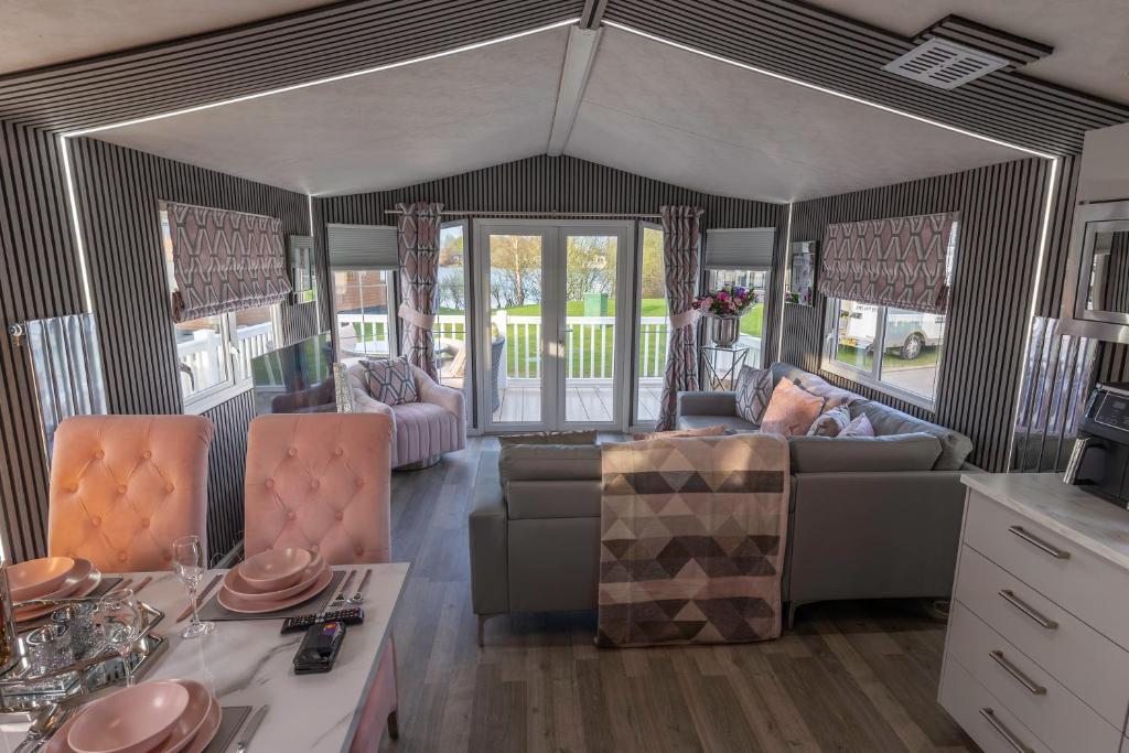 a living room with a couch and a table at Tattershall VIP Retreat - Hot tub, stunning lakeside views, newly refurbished to an amazing 5 star standard in Tattershall