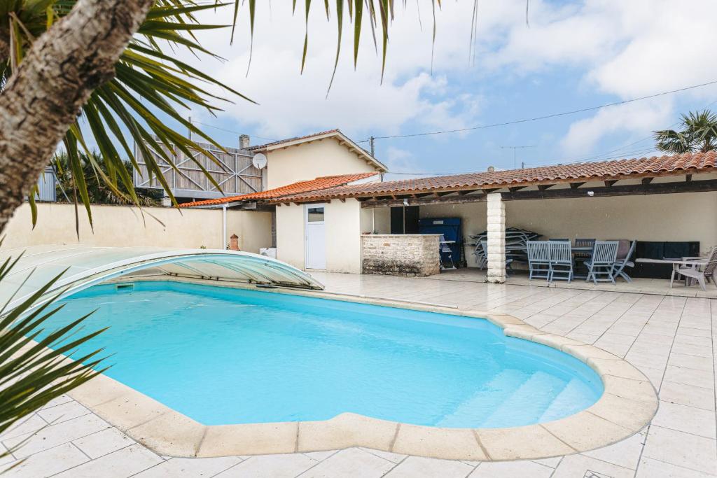 a swimming pool in front of a house at Maison Boyardville Piscine Chauffée in Saint-Georges-dʼOléron