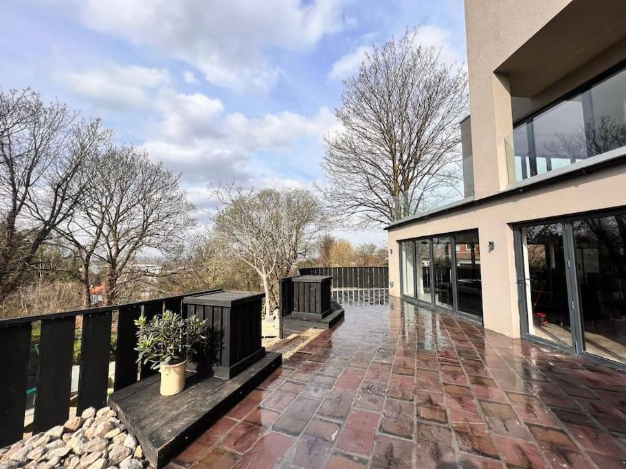 a balcony of a house with a brick patio at Designer home on a hill with magical views of London, 5br in Belvedere