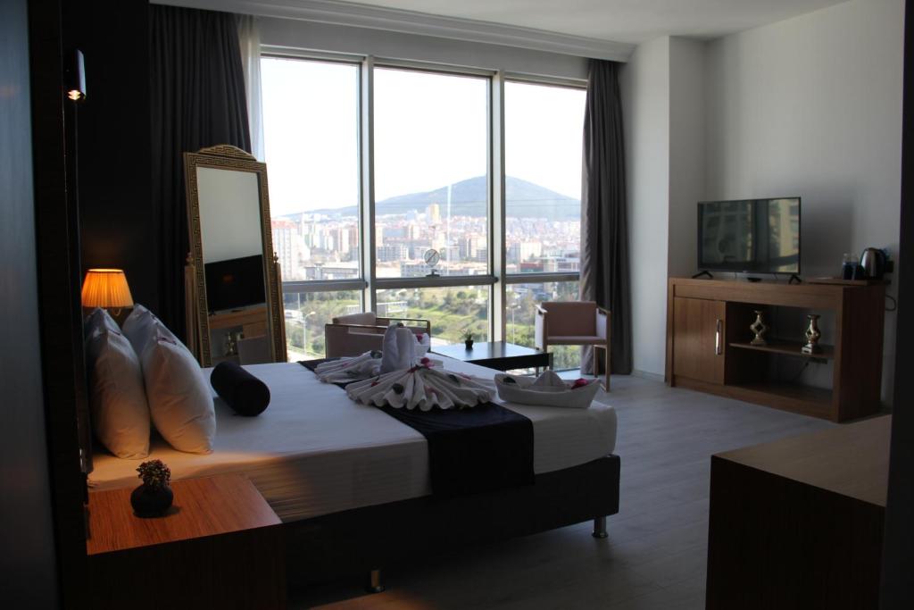 イスタンブールにあるVplus hotel atasehirのベッドと大きな窓が備わるホテルルームです。