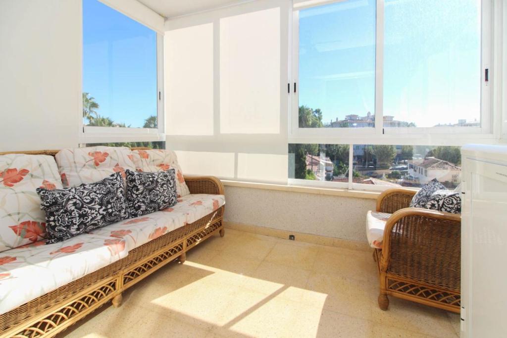 a living room with a couch and two windows at Apartamento Golf Pau Casals in Albir
