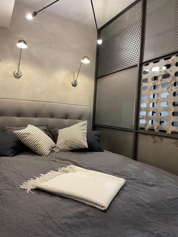 a bed with a white pillow on top of it at Premium Modern Apartments-City Center by Urban Escape in Krakow