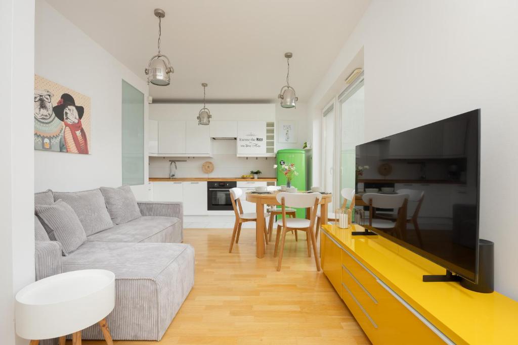 un soggiorno con divano, TV e tavolo di Two-bedroom Apartment with Terrace and Parking by Renters a Varsavia