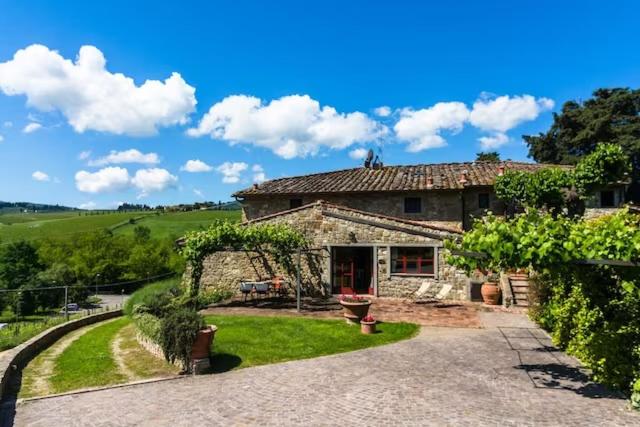 a large stone house with a yard with a yard at Primerose in Greve in Chianti