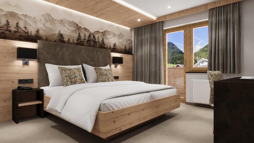 a bedroom with a large bed and a large window at Hotel Garni Pfeifer in Ischgl