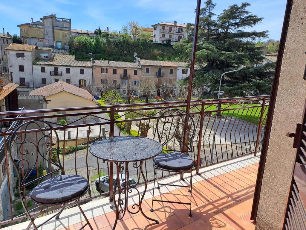 - Balcón con mesa y 2 taburetes en Casa Ai giardini, en Gradoli